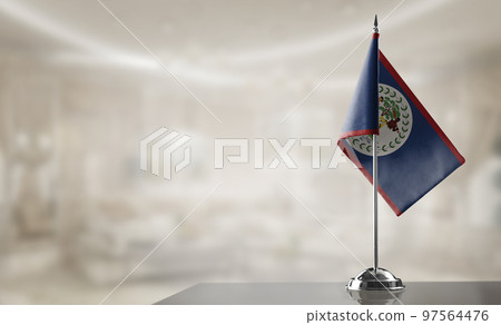 A small Belize flag on an abstract blurry background A small Belize flag on an abstract blurry background 97564476