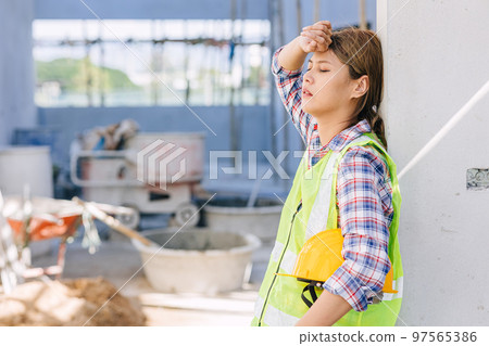 woman worker tired from work hard overwork fatigue be sick at construction site woman worker tired from work hard overwork fatigue be sick at construction site 97565386