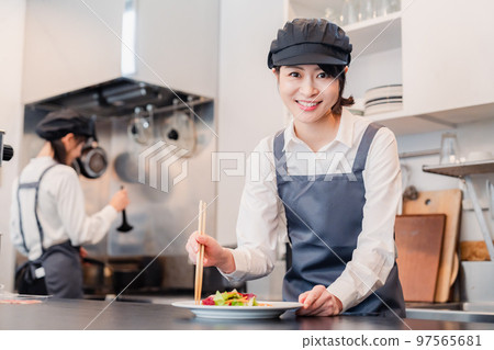 Two female staff working in a restaurant kitchen 97565681