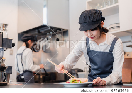 Two female staff working in a restaurant kitchen 97565686