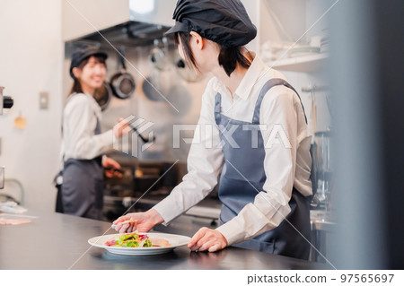 工作在餐館廚房裡的兩名女性職員 工作在餐館廚房裡的兩名女性職員 97565697