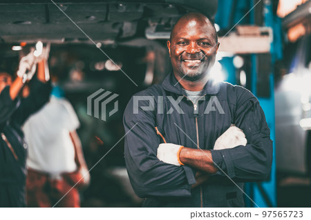 portrait garage mechanic professional worker car engine service looking camera smile arm crossed portrait garage mechanic professional worker car engine service looking camera smile arm crossed 97565723