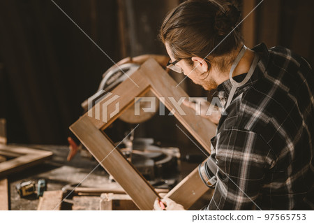 carpenter male wood builder worker making wooden furniture job in workshop 97565753