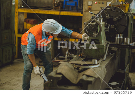 Industry male engineer worker safety check machine service fix setup working in lathe steel metal factory 97565759