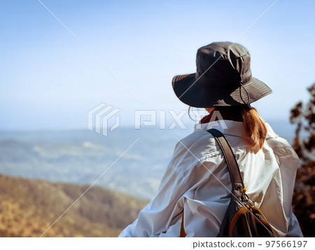Woman watching beautiful nature mountain landscape sitting on viewpoint. Popular tourist destination. Traveling, hiking, freedom and active lifestyle concept. Concept of an ideal resting place. Woman watching beautiful nature mountain landscape sitting on viewpoint. Popular tourist destination. Traveling, hiking, freedom and active lifestyle concept. Concept of an ideal resting place. 97566197