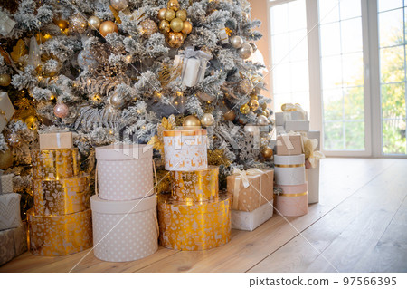 Christmas presents under the Christmas tree. New Year's and Christmas. Wrapped Gift. Beautiful packaging. Ribbon and bow on the packaging. 97566395