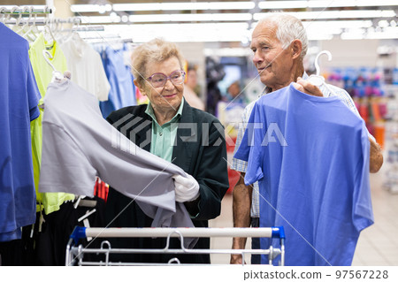 mature european couple chooses tee shirt in clothing department of supermarket 97567228