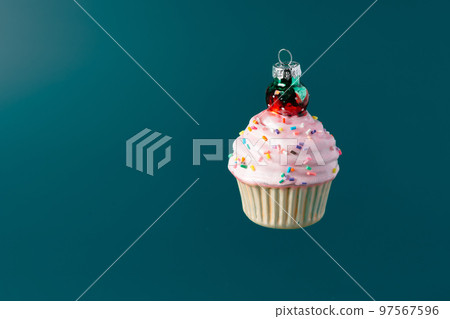 Christmas sweet cupcake bauble on dark green background Christmas sweet cupcake bauble on dark green background 97567596