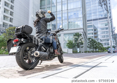A female rider touring Yokohama on a cruiser bike 97569149