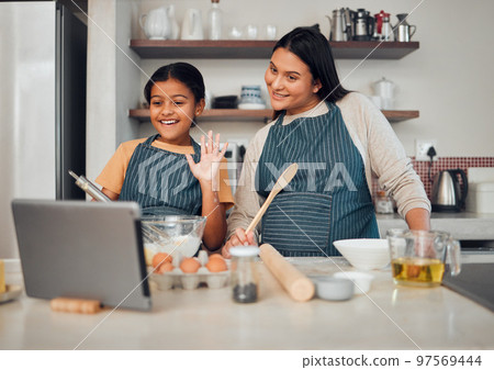 Family, baking and tablet while child wave hello at video call, food blog or zoom with mother and daughter in home kitchen. Content creator or influencer woman and girl teaching cake recipe online 97569444