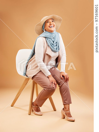Muslim woman, fashion scarf or chair in studio background in Dubai stylish, trendy hats or cool arabic clothes. Happy smile, laughing or mature Islamic model on furniture seat with hijab fabric scarf Muslim woman, fashion scarf or chair in studio background in Dubai stylish, trendy hats or cool arabic clothes. Happy smile, laughing or mature Islamic model on furniture seat with hijab fabric scarf 97569601