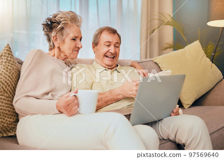 Sofa, laptop and senior couple in living room on comedy show, streaming social media video or meme for retirement lifestyle. Happy old woman drink coffee with her partner on couch and home technology 97569640