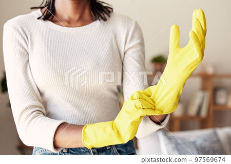 Cleaning, rubber gloves and hands of woman in living room for hygiene, protection and disinfection. Dirt, dust and bacteria with girl cleaner at home for sanitary, housekeeping and domestic chores 97569674