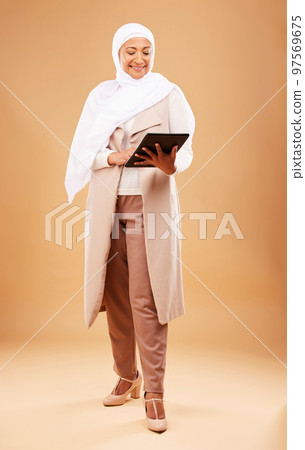 Happy muslim woman, tablet and technology on studio background for website, social network and internet app on studio background. Mature lady in islamic hijab search digital connection in Malaysia 97569675