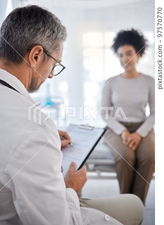 Doctor, consultation and writing on clipboard with patient in hospital office for symptoms, records or notes. Healthcare, wellness or black woman consulting medical physician with checklist in clinic 97570770