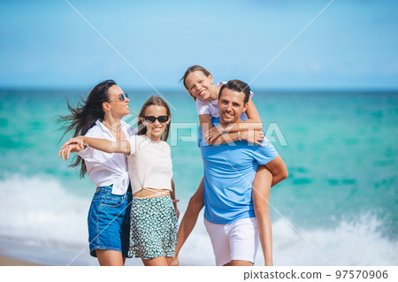 Family of four have fun together on beach vacation on Caribs 97570906