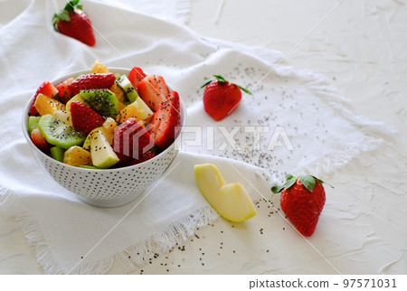 Bowl of healthy fresh fruit salad on white napkin Bowl of healthy fresh fruit salad on white napkin 97571031