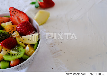 Bowl of healthy fresh fruit salad on white napkin Bowl of healthy fresh fruit salad on white napkin 97571032