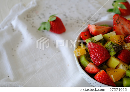 Bowl of healthy fresh fruit salad on white napkin Bowl of healthy fresh fruit salad on white napkin 97571033