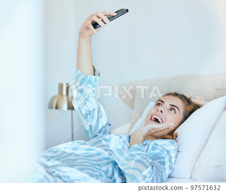 Selfie, girl in bed and photography with phone, technology and memory, smile and happy, young gen z with social media content creation. Happiness in picture, morning and smartphone, wifi 5g network. 97571632