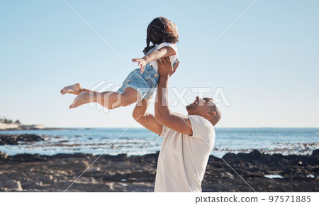 Beach, man holding girl in air and playful for vacation, summer and weekend break. Father swing daughter, relax and bonding at seaside, holiday and loving together for quality time, outdoor and smile 97571885