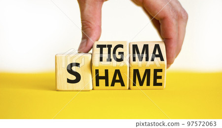 Stigma or shame symbol. Concept words Stigma or Shame on wooden cubes. Businessman hand. Beautiful yellow table white background. Business stigma or shame concept. Copy space. 97572063