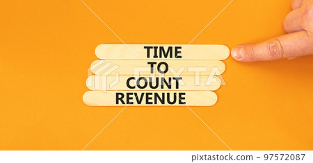 Time to count revenue symbol. Concept word Time to count revenue on wooden sticks. Businessman hand. Beautiful orange table orange background. Business and time to count revenue concept. Copy space. 97572087