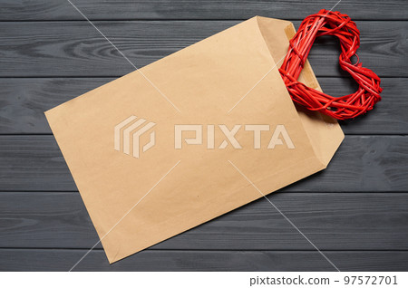 Blank envelope on wooden plank table with heart shape 97572701