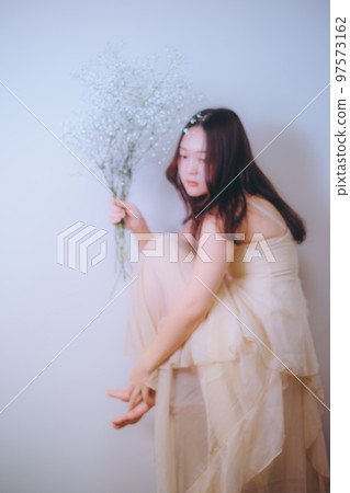 Photo of a young woman holding flowers 97573162