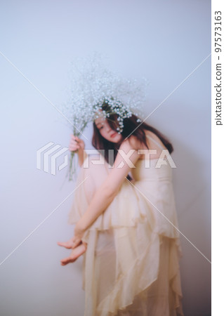 Photo of a young woman holding flowers 97573163