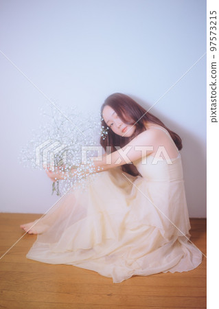 Photo of a young woman holding flowers Photo of a young woman holding flowers 97573215
