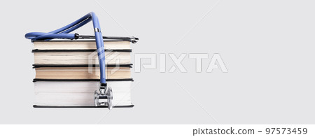 Banner with medical education concept. Books stack with stethoscope. Getting medicine knowledge, study for becoming doctor. Copy space on grey background 97573459