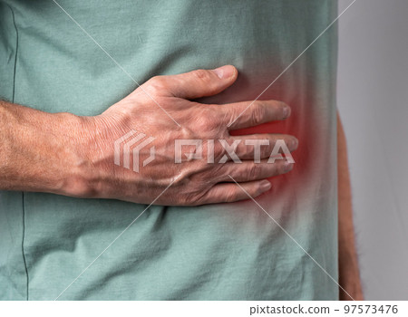 Liver pain. Man hand holding abdomen right side with red point closeup. Diseases, alcohol abuse, health care, treatment concept 97573476