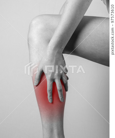 Shin pain. Woman holding leg with red spot. Tendons, muscles inflammation, injury, bone bruise consequences. Black and white. 97573610