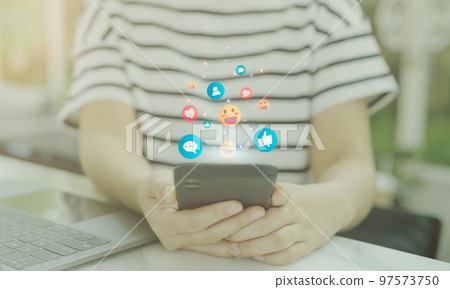 Social media concept. Woman using smart phone with notification icons of like, message, Smile Love Like emoticon, and Chat above smartphone screen. 97573750