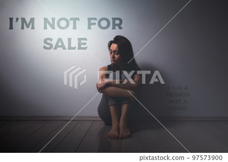 Young sad woman with beatings on the body, sitting on the floor in the room. There is a light wall in the background. Human trafficking, sexual slavery concept. The inscription I'm not for sale Young sad woman with beatings on the body, sitting on the floor in the room. There is a light wall in the background. Human trafficking, sexual slavery concept. The inscription I'm not for sale 97573900