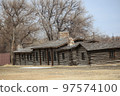 Log cabins displayed outdoors. 97574100