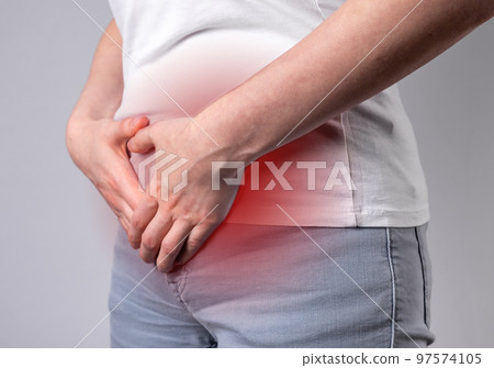 Woman suffering from menstruation cramps. PMS, stomachache, gynecological problems. Woman hands holding lower abdomen with red spot closeup. Health problems, medicine concept. Woman suffering from menstruation cramps. PMS, stomachache, gynecological problems. Woman hands holding lower abdomen with red spot closeup. Health problems, medicine concept. 97574105