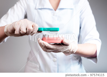 Dentist using toothbrush and jaw model to show how to clean teeth. Professional tooth whitening, plaque removal. Stomatology, oral hygiene concept. 97574115
