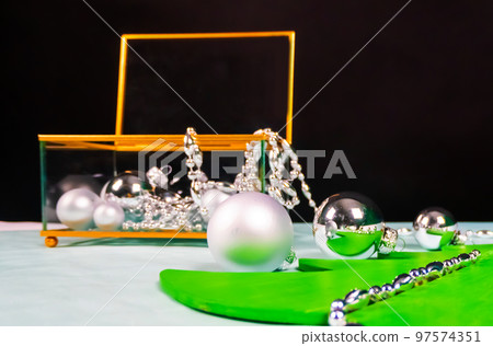silver ornaments come out of a glass and gold casket and decorate a flat Christmas tree on a black and blue background silver ornaments come out of a glass and gold casket and decorate a flat Christmas tree on a black and blue background 97574351