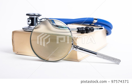 Book with stethoscope and magnifying glass. Medical education, search of information about medicine, health problems and treatment. 97574371