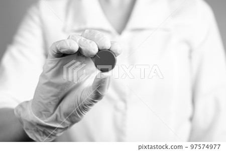 Doctor holding pill. Erroneous medication prescription, wrong dosage or medical decision, malpractice, tablets side effects concept. Black and white. 97574977