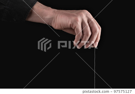 Man hand holding string for manipulation, exploit, control. Abuse and toxic relationship. Manipulator making person feel fearful, guilty 97575127
