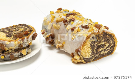 Christmas cake Makowiec with poppy seeds,traditional polish festive pie covered with sugar icing, walnuts, dried fruits on white background, some slices of strudel on plate Horizontal Christmas cake Makowiec with poppy seeds,traditional polish festive pie covered with sugar icing, walnuts, dried fruits on white background, some slices of strudel on plate Horizontal 97575174