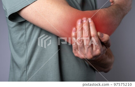 Man suffering from elbow pain and holding painful hand with red point closeup. Hand injury. Health care, joint diseases concept 97575210