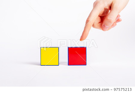 Choice concept. Forefinger pointing to red cube instead of yellow one. Making decision between two variants, proposals 97575213