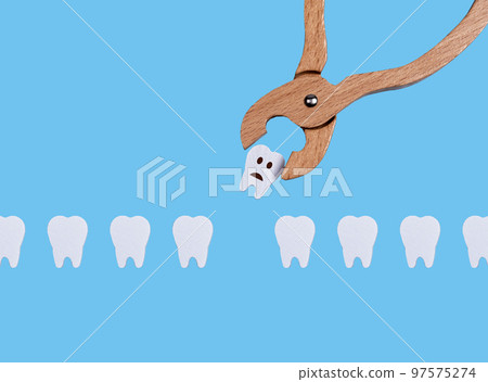Teeth row and dental forceps. Pulling bad sick tooth with sad emoji because of decay, periodontal disease. Oral health and dentist work concept on blue background. Children game at doctor. 97575274