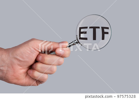 ETF acronym through magnifying glass in male hand ETF acronym through magnifying glass in male hand 97575328