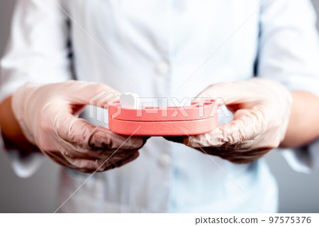 Dentist holding jaw model with single tooth. Teeth loss, extraction, replacement with permanent ones. Poor oral hygiene, caries, periodontal disease, injury. Doctor hands in gloves Dentist holding jaw model with single tooth. Teeth loss, extraction, replacement with permanent ones. Poor oral hygiene, caries, periodontal disease, injury. Doctor hands in gloves 97575376