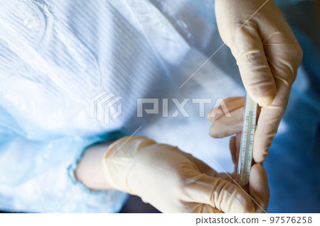 Hands holding medical thermometer. Hands holding medical thermometer. 97576258